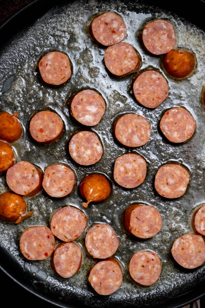 melt butter in a large saute pan, and brown sausages, 3-4 minutes a side over medium heat. 