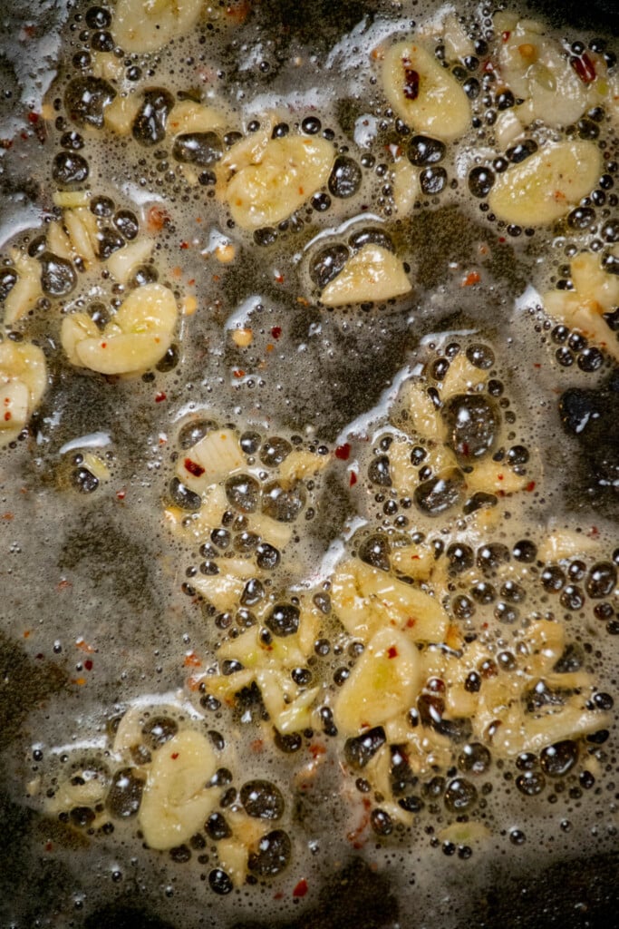 melt half of the butter in the pan you cooked the chicken in, and add the garlic and red pepper flakes.  Cook for 1 minute, until just fragrant 