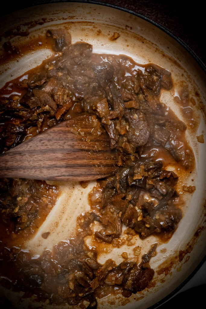 you're looking for the pan to be mostly dry, and most the wine has evaporated/flavored the mushrooms 