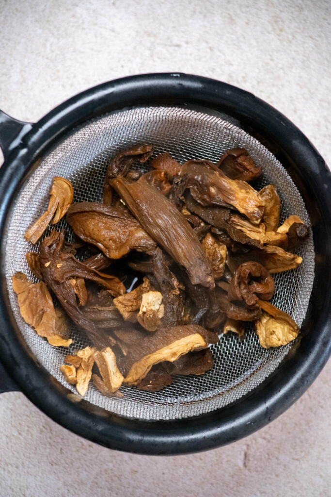 after 30 minutes, strain the mushrooms, and reserve the soaking liquid. Roughly chop the softened mushrooms into small pieces 