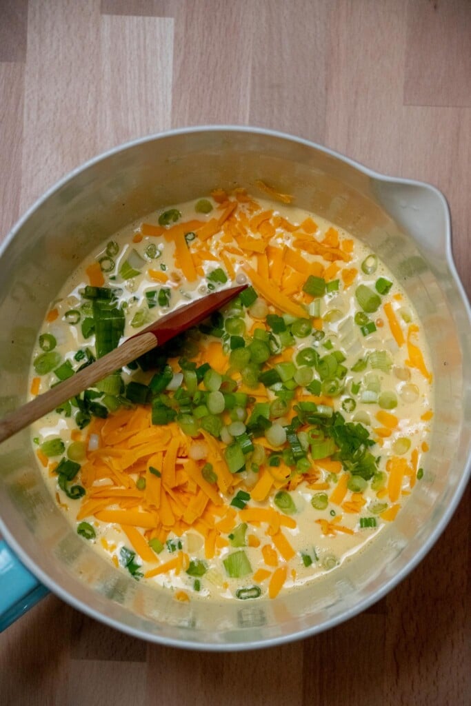 using a spatula, fold in the shredded cheddar and thinly sliced scallions. 