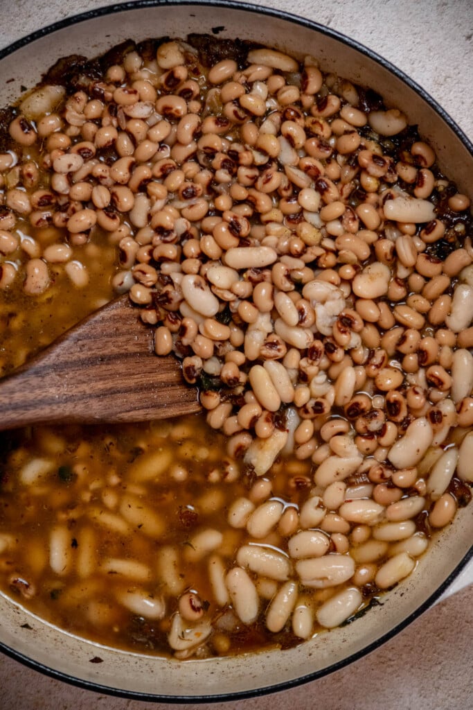 Add the drained black eyed peas and chicken broth to the pan 