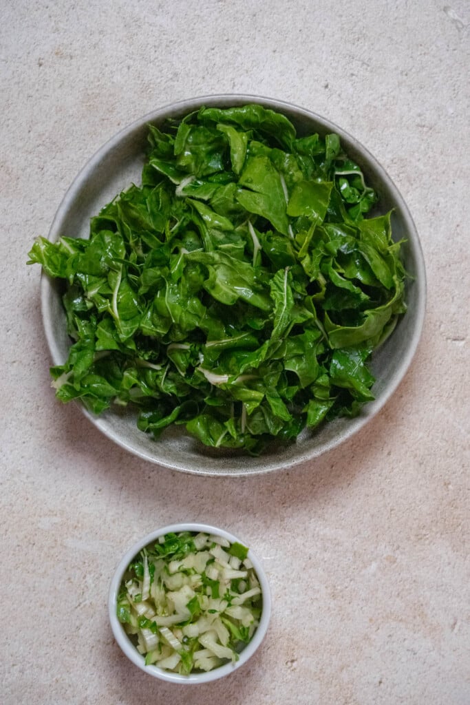 Separate the Swiss chard stems and leaves. Cut the leaves into thin strips, and the stems into small pieces