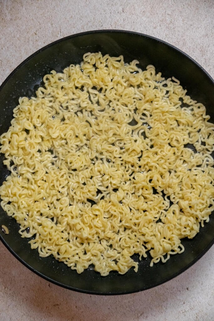 Heat avocado oil and butter in a frying pan over high heat, then add the noodles in a single layer. 