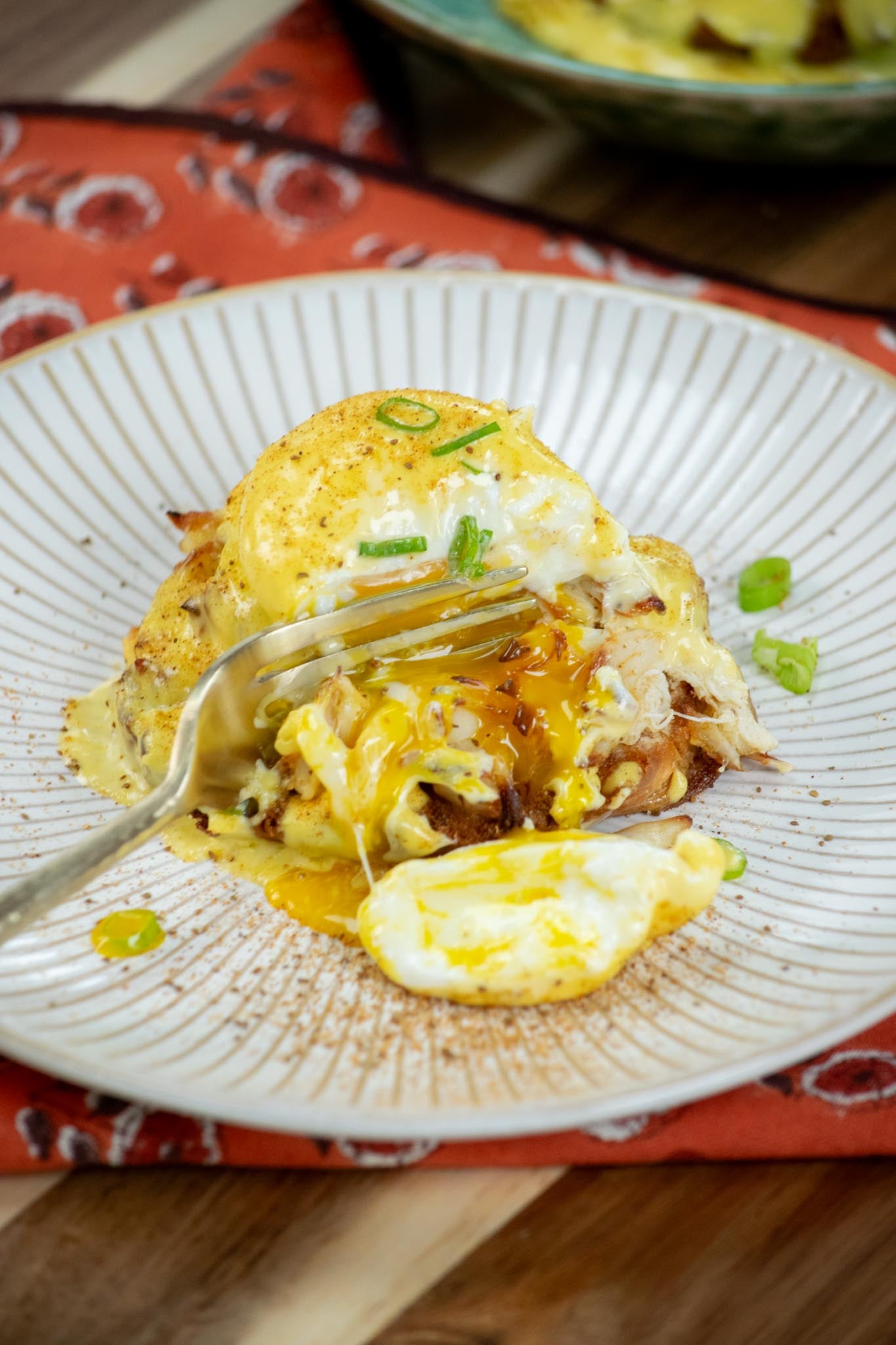 A fork cutting into a crab benedict.