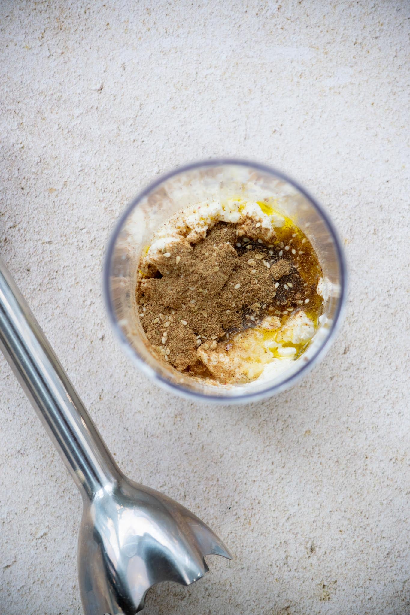 Ingredients to make feta dressing in a glass.
