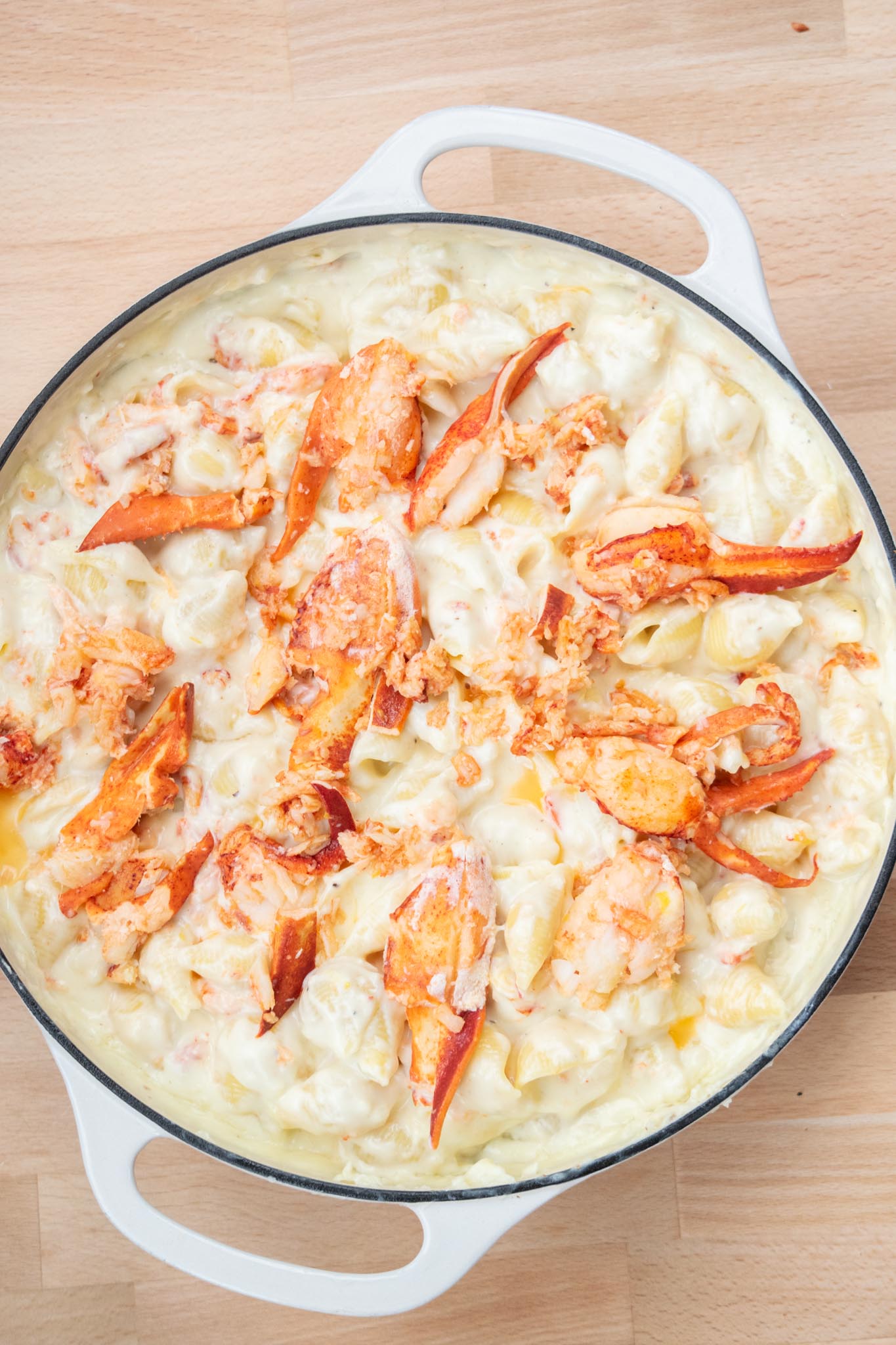 Lobster meat spread over the top of the dish of macaroni and cheese.