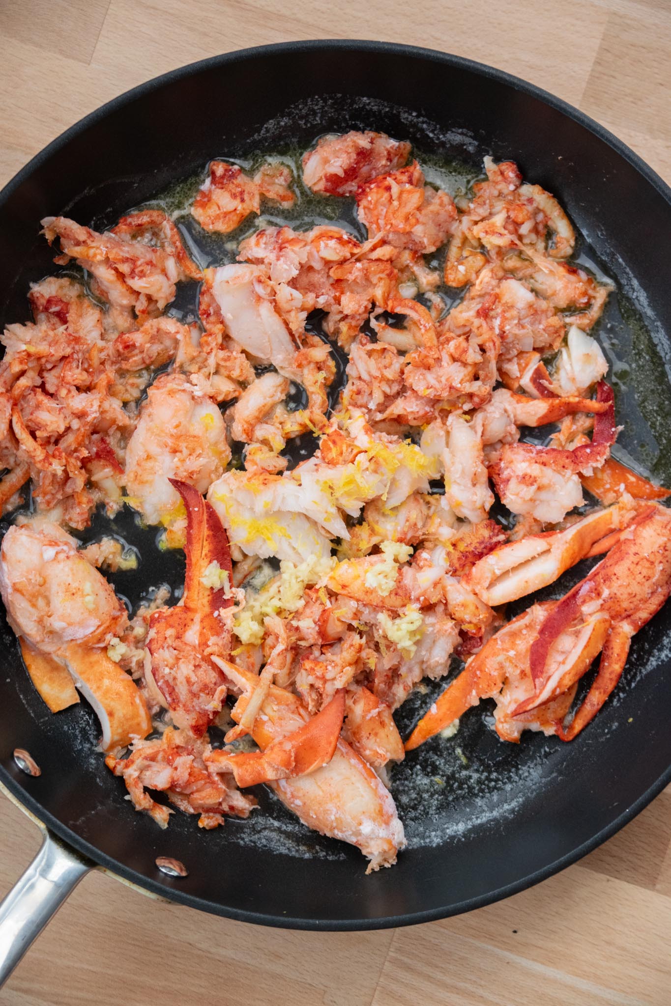 Lobster meat cooking in a skillet.