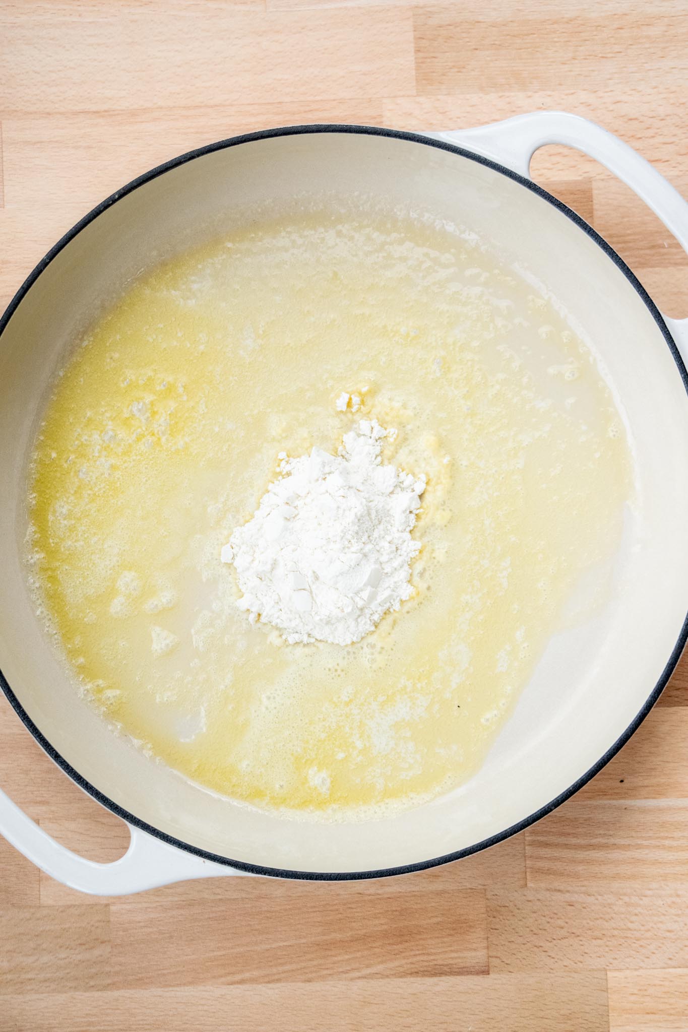 Flour added to melted butter in a pot.